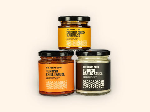 Three jars of different sauces arranged in a triangular formation. From top to bottom: a jar labeled 'Chicken Shish Marinade', a jar labeled 'Turkish Chilli Sauce', and a jar labeled 'Turkish Garlic Sauce'.