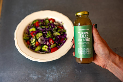 Salad dressing being held in front of a salad
