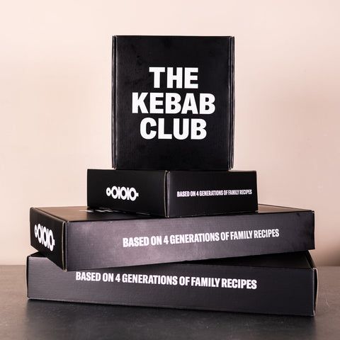 Stack of black boxes with 'The Kebab Club' branding on a neutral background